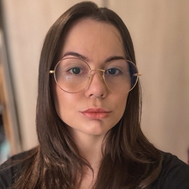 Retrato de Ana Beatriz Manso, de cabelos castanhos e óculos de armação dourada